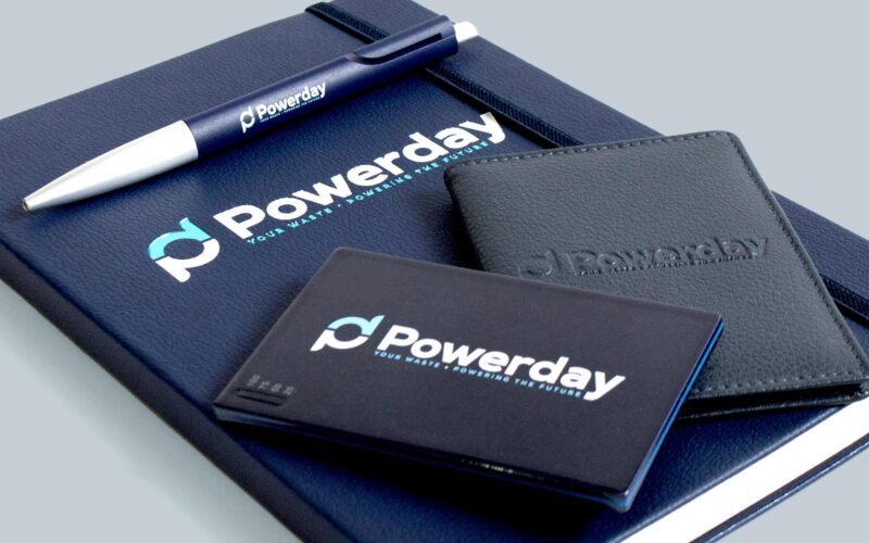 A pen, a notebook, and a cardholder, all featuring the 