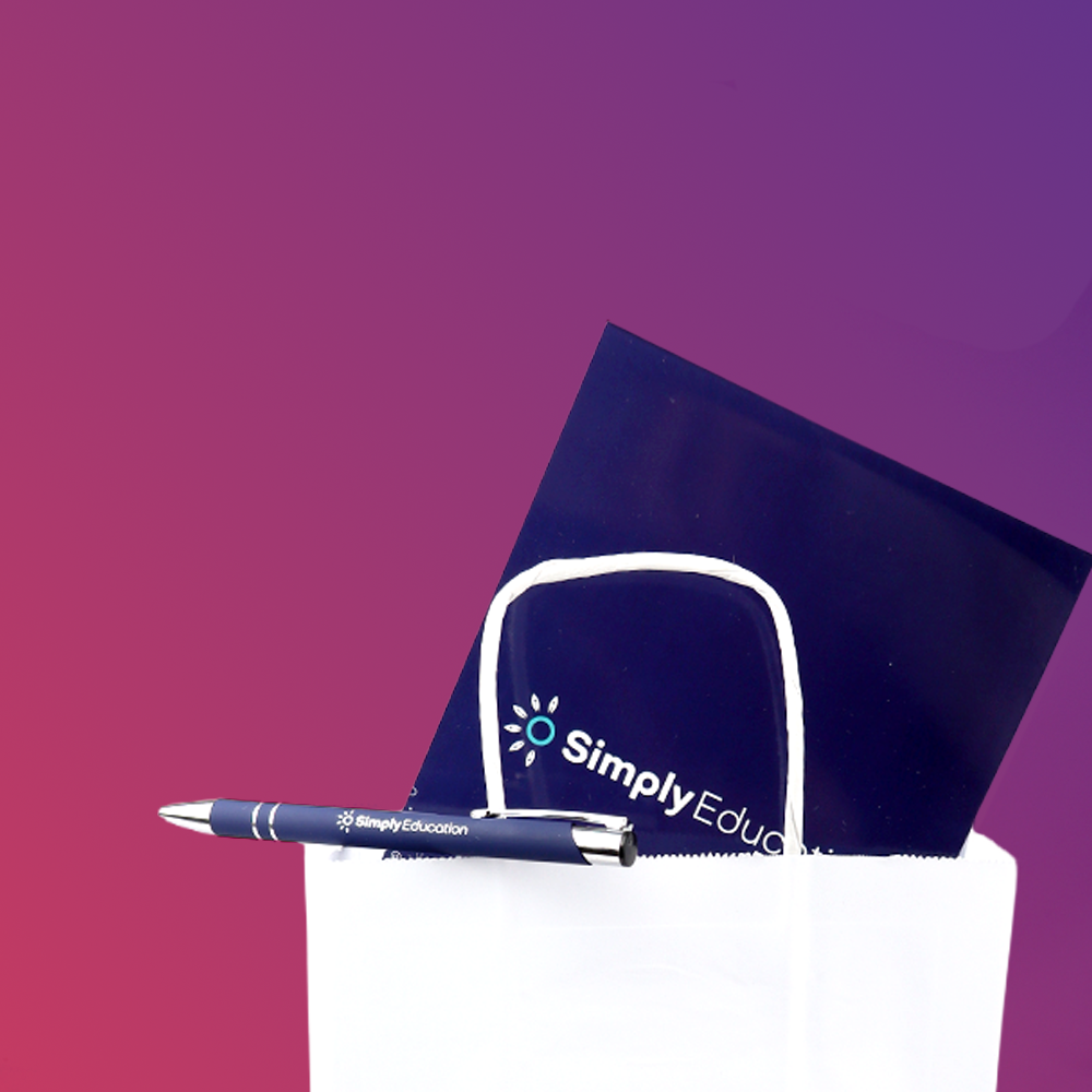 A white gift bag containing a dark blue folder with 
