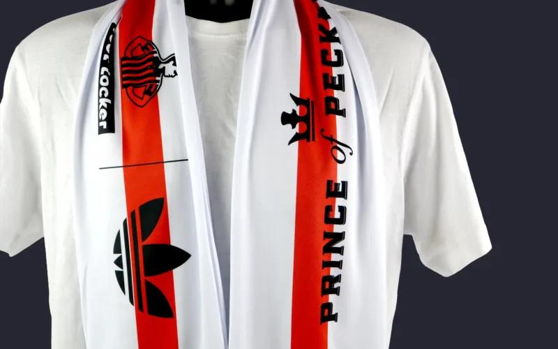 A white scarf with red stripes, featuring logos and text that reads 