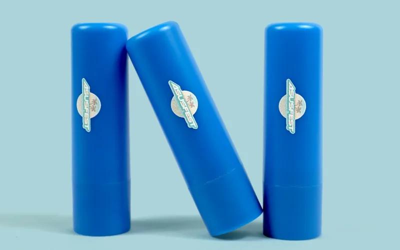 Three blue cylindrical objects with logos, positioned in a triangular formation.