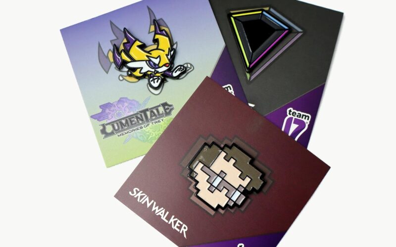 Three collectible pin designs featuring illustrations and logos: one of a yellow creature labeled 