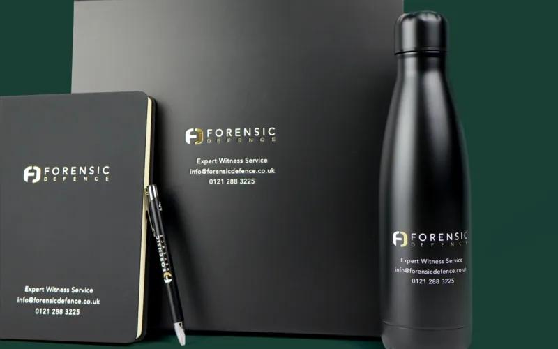 A black notebook, pen, and water bottle with the 