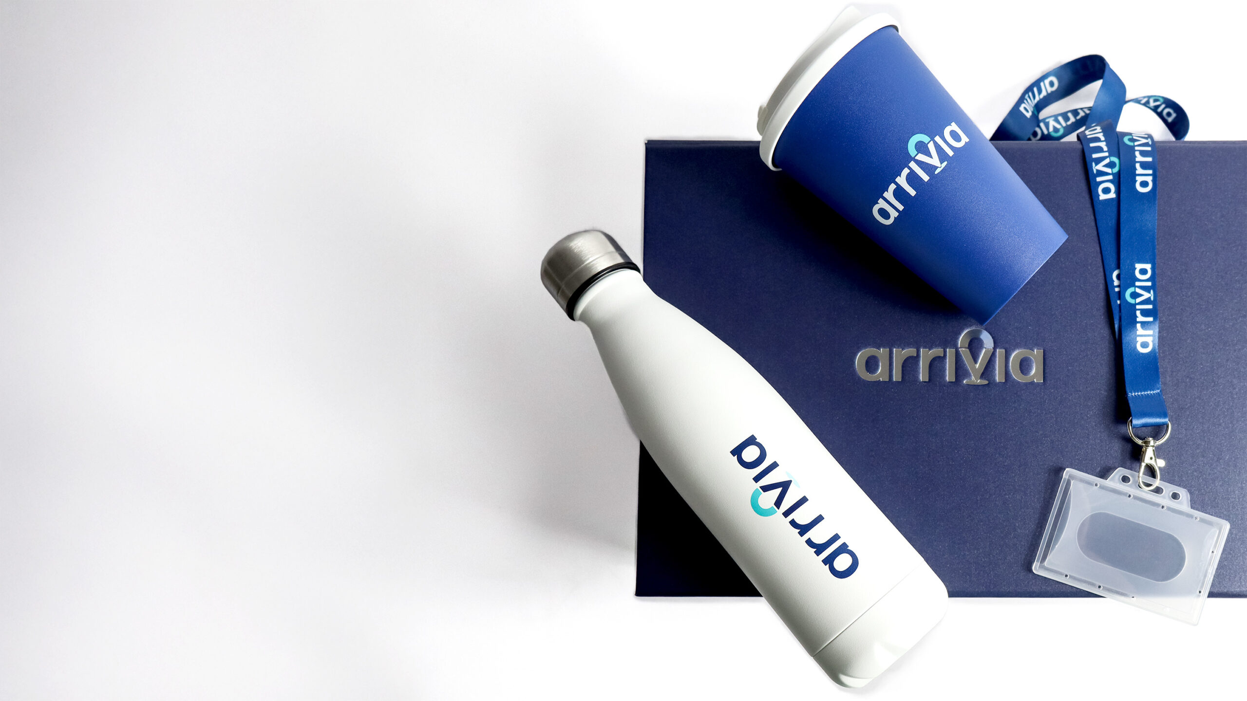 A white insulated water bottle, a blue coffee cup, a blue lanyard, and a dark blue box with the word 