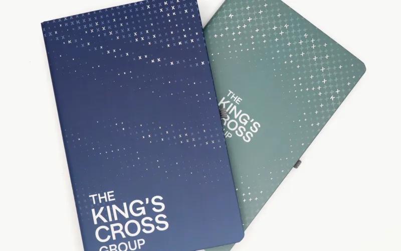 Two notebooks with a gradient design; one is dark blue and the other is green, both featuring 