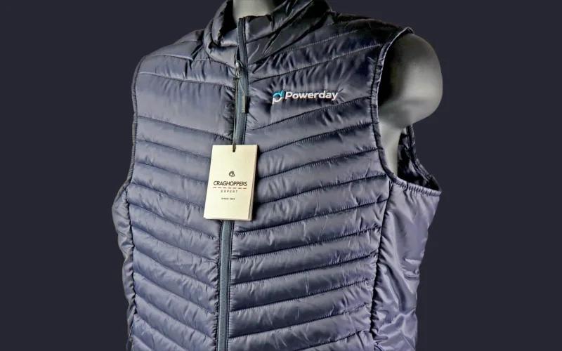 A navy blue puffer vest displayed on a mannequin with a tag that reads 