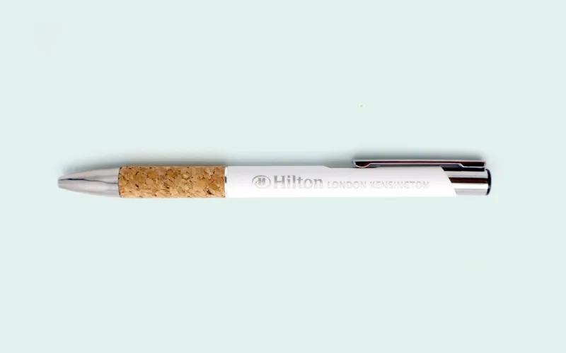 A pen featuring a cork grip and white body, marked with 