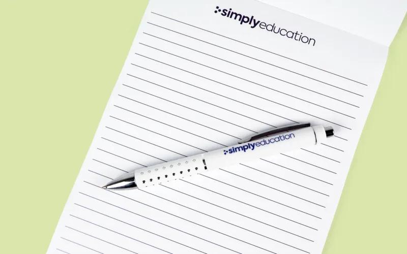 A notepad with lined pages and a white pen labeled 