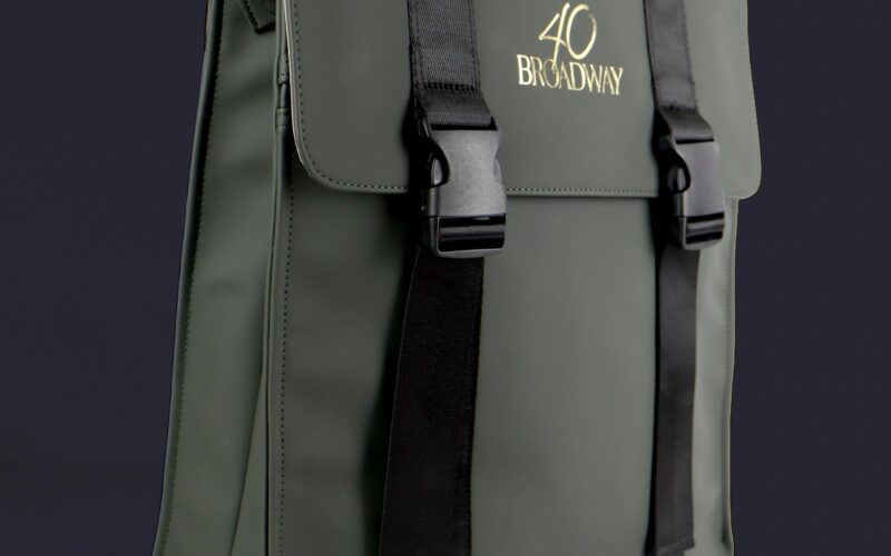 A green backpack with black straps and a logo reading 