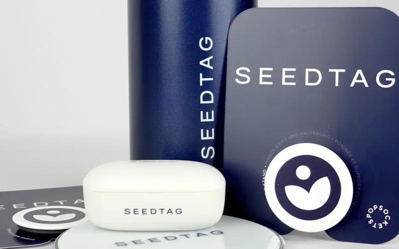 A collection of SEEDTAG products including a white case, round mirror, and two cards, all featuring the SEEDTAG logo on a light background.