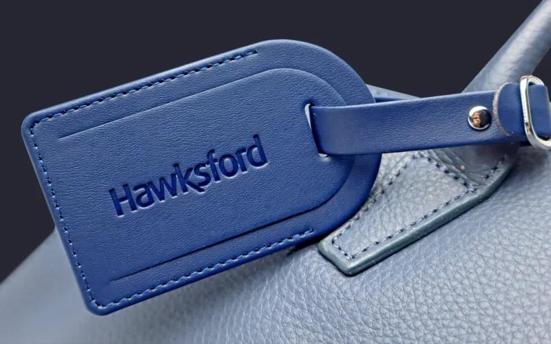 A close-up of a blue leather tag with the embossed word 