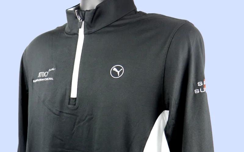 A black long-sleeve shirt with a half-zip collar, featuring white accents and logos.